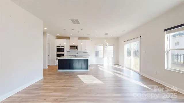 a large kitchen with granite countertop a large counter top stainless steel appliances and cabinets