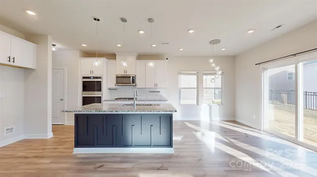 a open kitchen with kitchen island a sink stainless steel appliances and cabinets