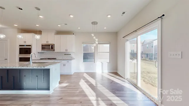 a large kitchen with stainless steel appliances granite countertop a large counter top a stove and a shower