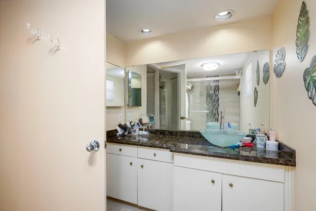 a bathroom with a granite countertop sink and a mirror