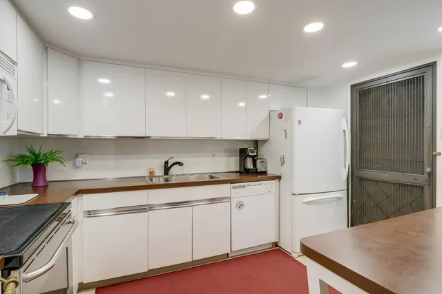 a kitchen with a sink a refrigerator and cabinets