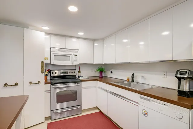 a kitchen with a sink a stove and cabinets