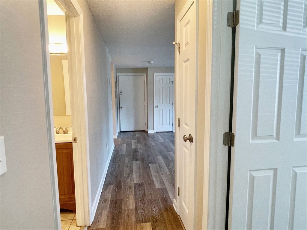 1617 Braley Road, Unit 82 New Bedford, MA 02745 - Photo 12 of 12 a view of a hallway with wooden floor and a bathroom