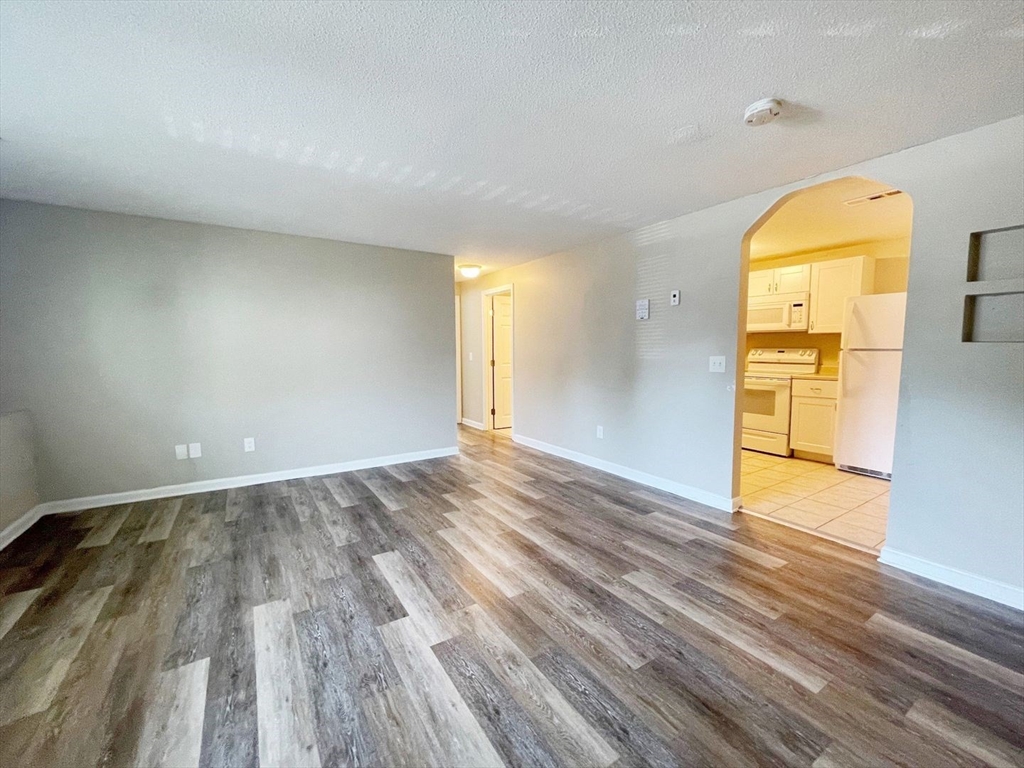 1617 Braley Road, Unit 82 New Bedford, MA 02745 - Photo 5 of 12 wooden floor in an empty room with a window