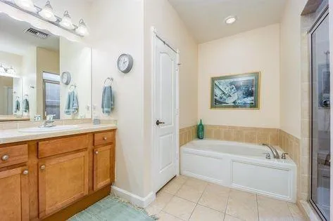 a bathroom with a tub a sink and a mirror