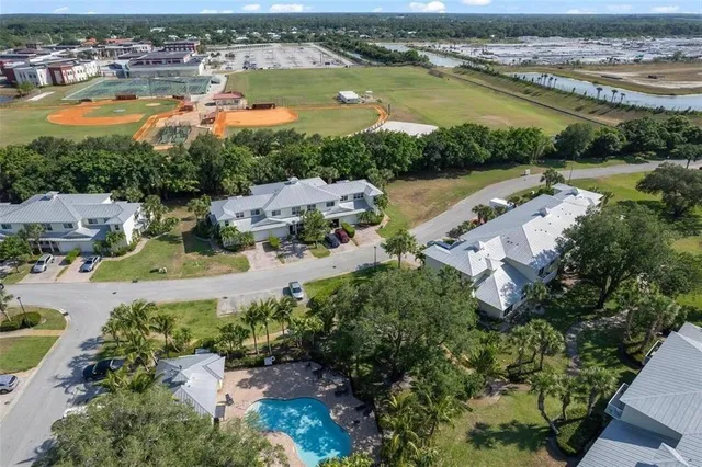 an aerial view of ocean and residential houses with outdoor space