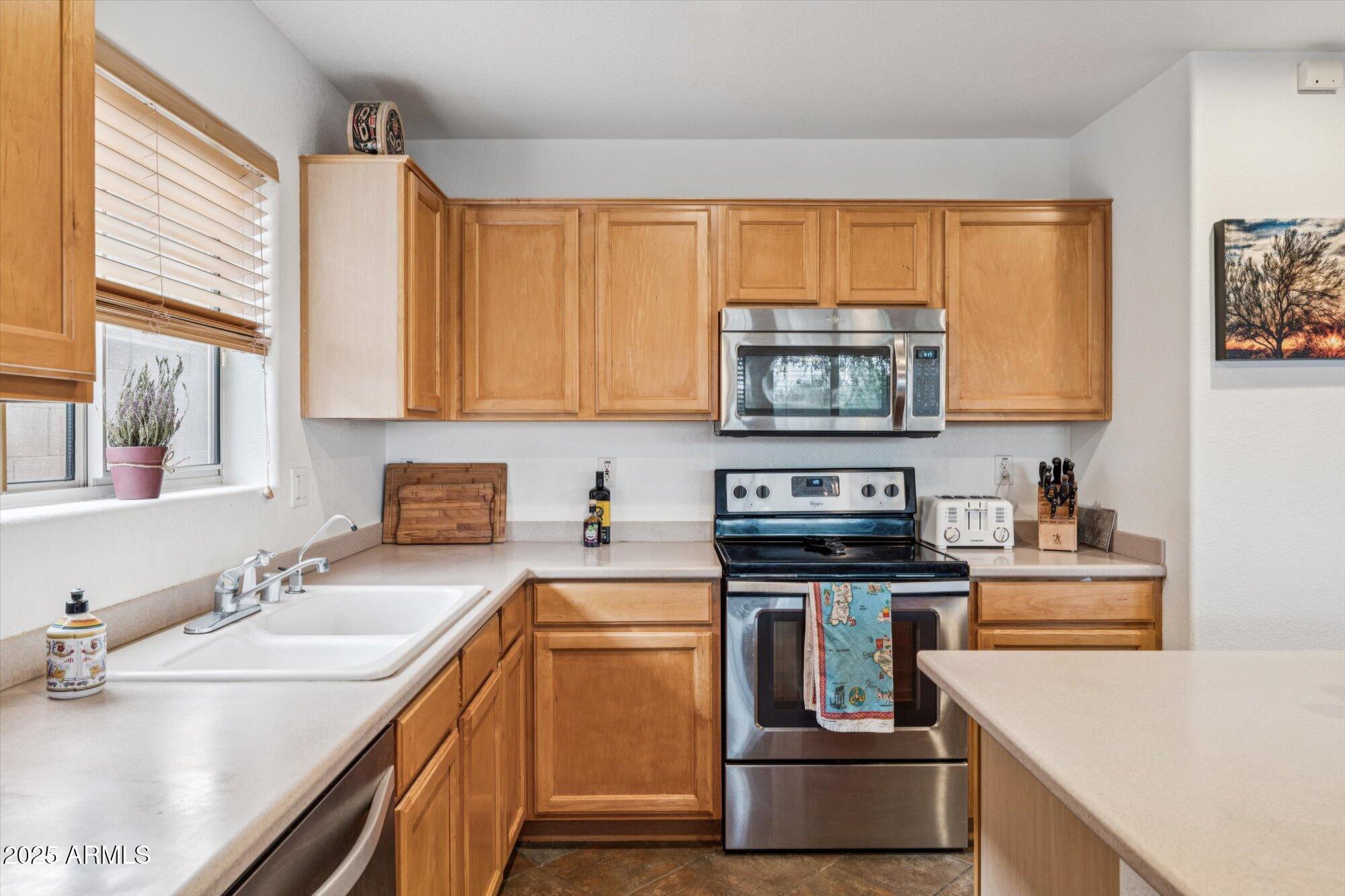 5128 East Via Dona Road Cave Creek, AZ 85331 - Photo 11 of 38 a kitchen with a stove a sink and a microwave