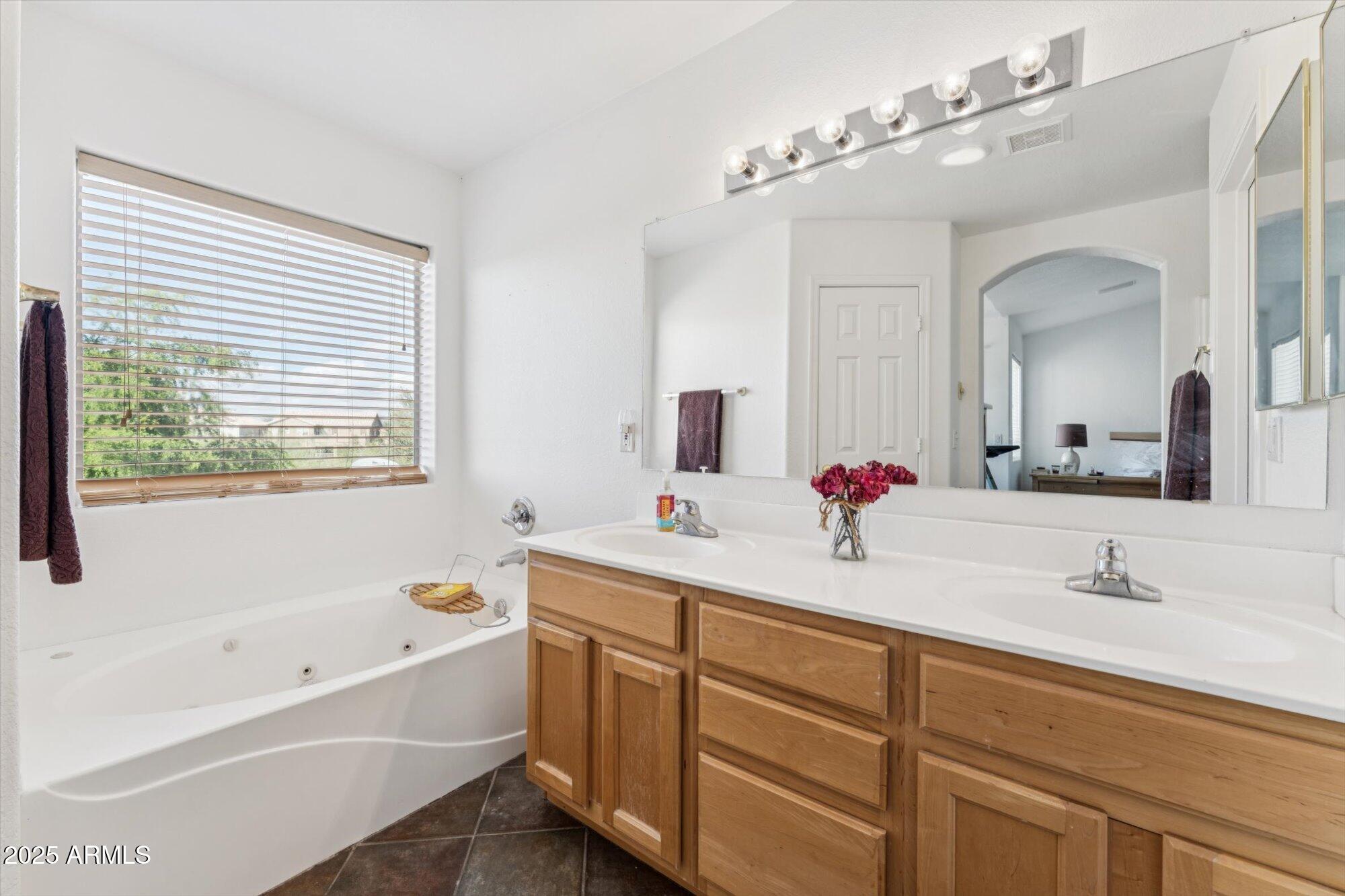 5128 East Via Dona Road Cave Creek, AZ 85331 - Photo 27 of 38 a bathroom with a bathtub a double vanity sink and mirror