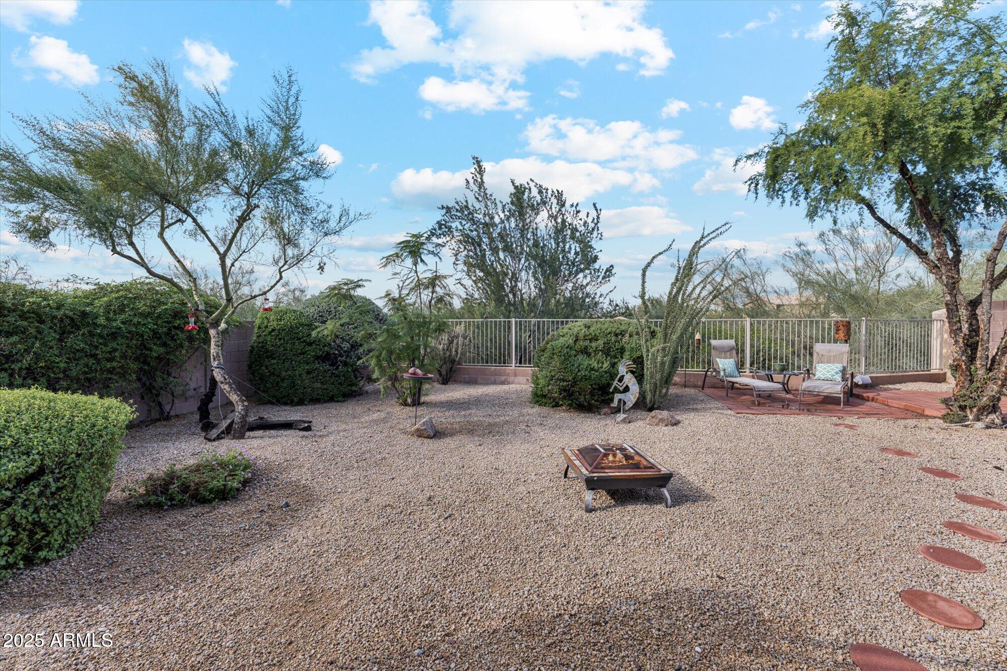 5128 East Via Dona Road Cave Creek, AZ 85331 - Photo 37 of 38 a backyard of a house with table and chairs under an umbrella