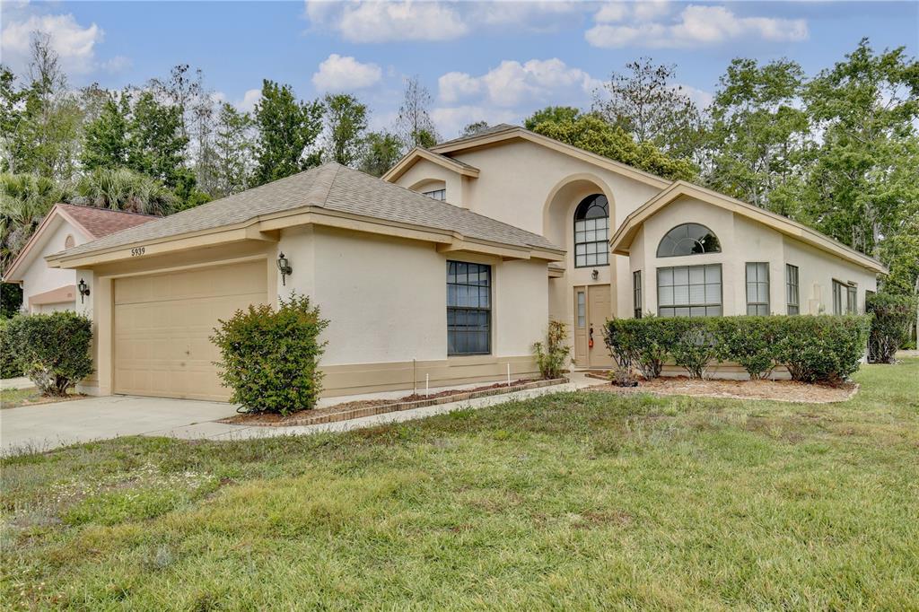 5939 Petunia Lane Orlando, FL 32821 - Photo 1 of 1 a front view of a house with a garden
