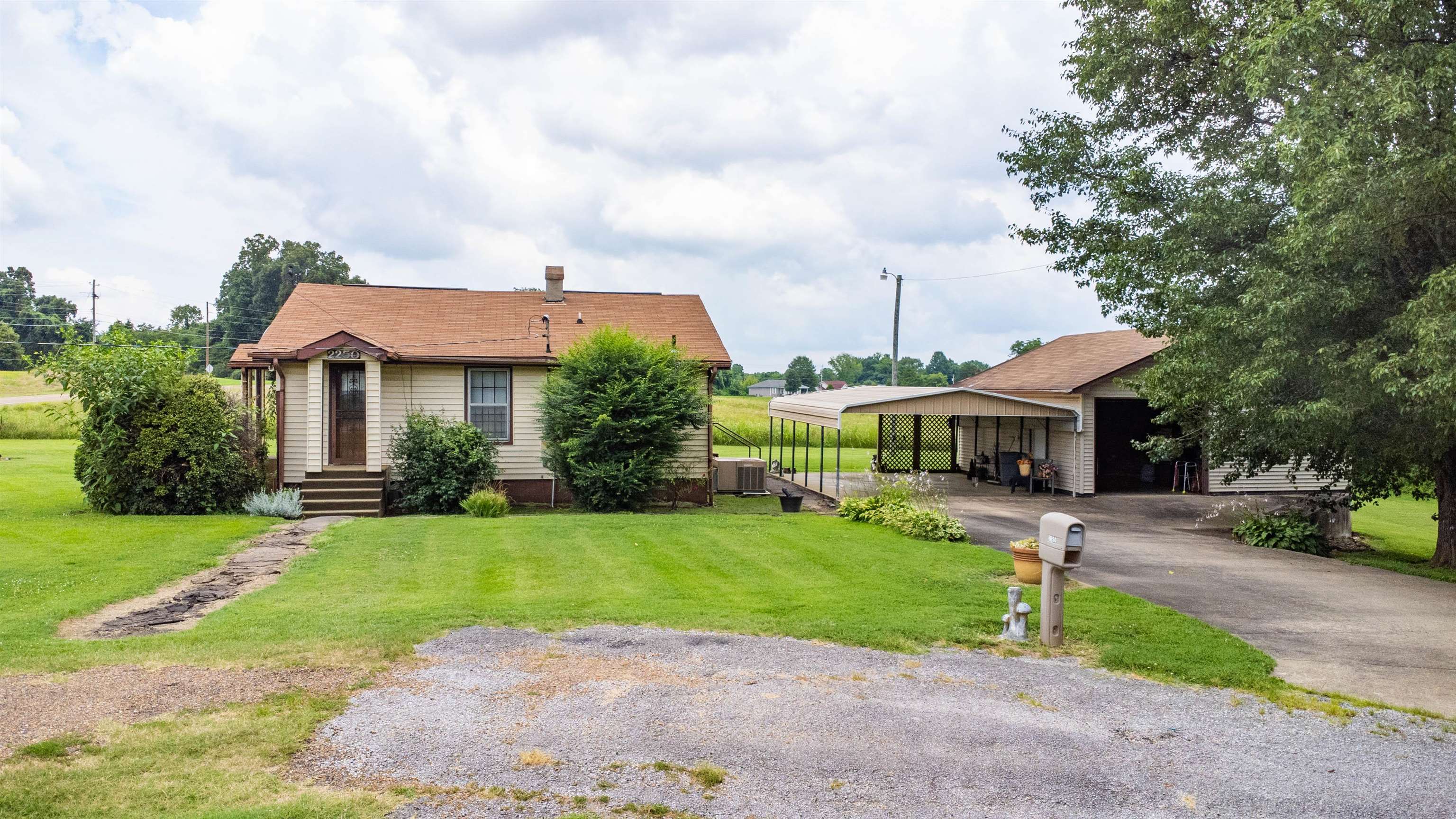 2250 Chisholm Lake Road Ripley, TN 38063 - Photo 1 of 32 a front view of a house with a garden and yard