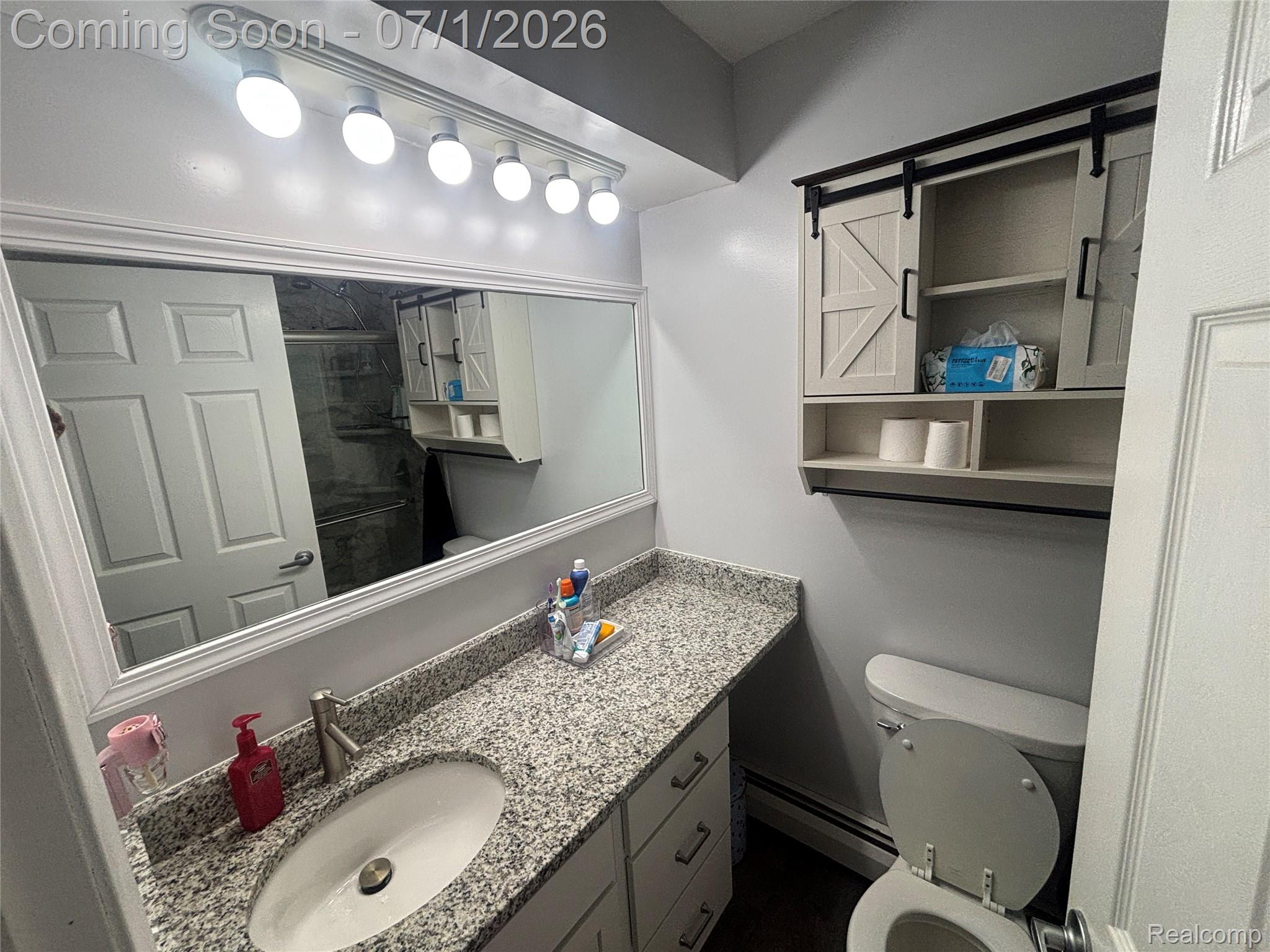 9844 Pine Knob Road Clarkston, MI 48348 - Photo 9 of 15 Bathroom vanity featuring a light granite-style countertop, undermount sink, and brushed nickel faucet
