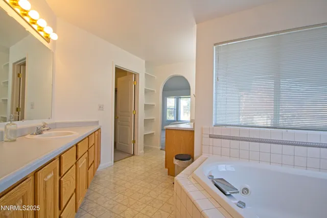 a bathroom with a tub sink and mirror
