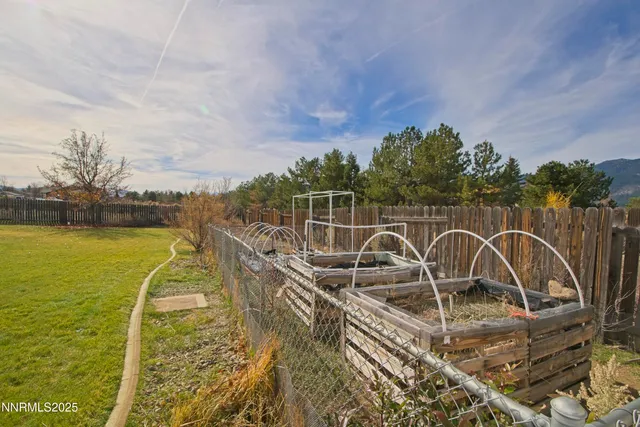 a view of a swimming pool with a table and chairs next to a yard