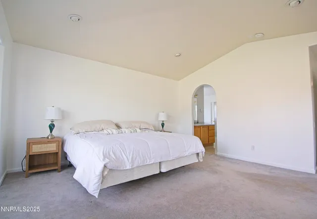 a bedroom with a bed lamp and wooden floor