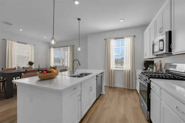 a kitchen with stainless steel appliances granite countertop a sink stove and wooden floor