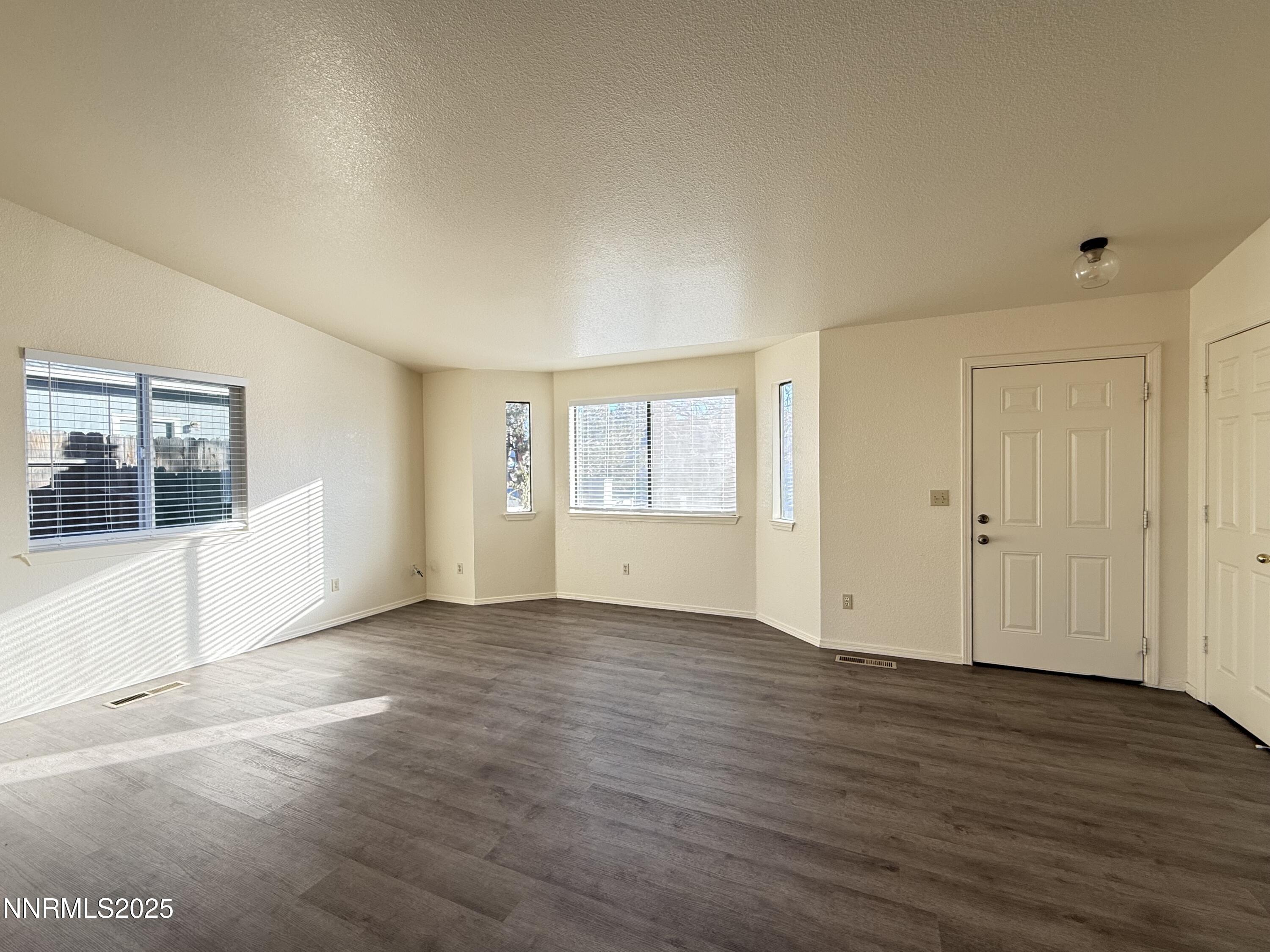 982 Ridgeview Drive Carson City, NV 89705 - Photo 3 of 16 a view of an empty room with wooden floor and a window