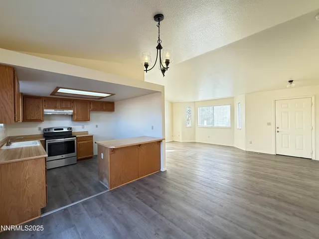 a kitchen with stainless steel appliances granite countertop a sink cabinets and wooden floor