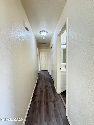 a view of a hallway with wooden floor