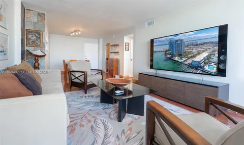 a living room with furniture a rug and a wall painting