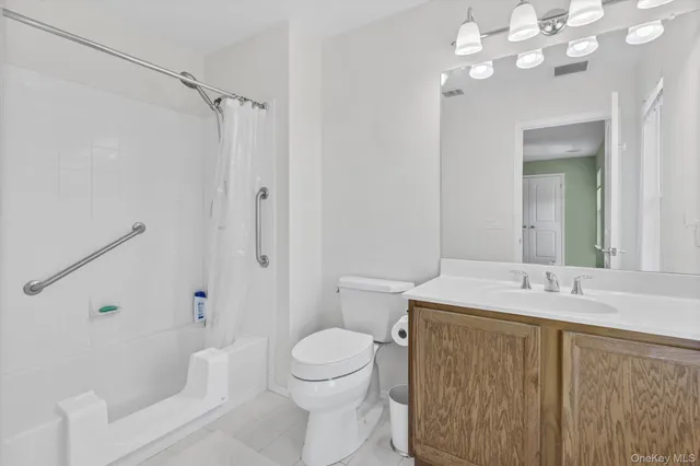 a bathroom with a sink a toilet a mirror a vanity and shower