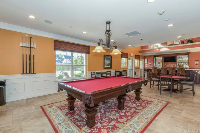 a room with pool table and windows
