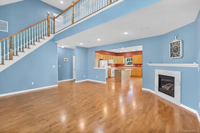 a view of empty room with wooden floor and fireplace