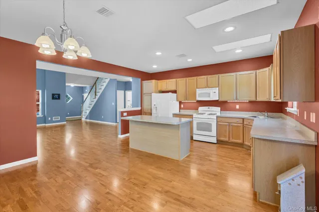 a view of kitchen with kitchen island granite countertop wooden cabinets and counter space