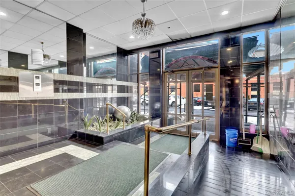 a living room with stainless steel appliances kitchen island granite countertop lots of furniture and a large window