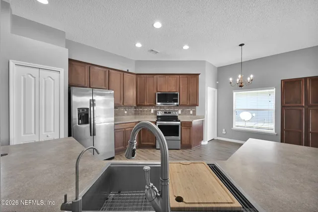 a kitchen with kitchen island a counter top space stainless steel appliances and cabinets