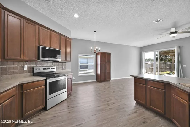 a kitchen with stainless steel appliances granite countertop a stove top oven a sink and a microwave