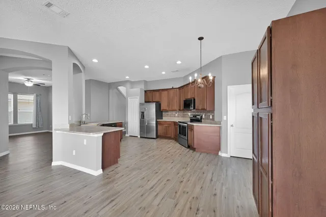 a large kitchen with kitchen island a large counter top space a sink stainless steel appliances and cabinets