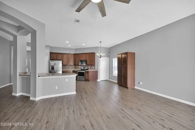 a view of kitchen with refrigerator microwave and wooden floor