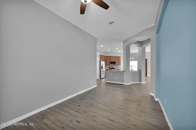 a view of a kitchen and an empty room with a kitchen