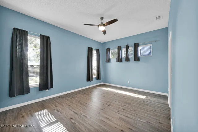 a view of empty room with wooden floor