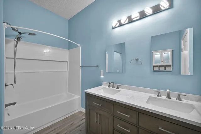 a bathroom with a tub a sink and mirror