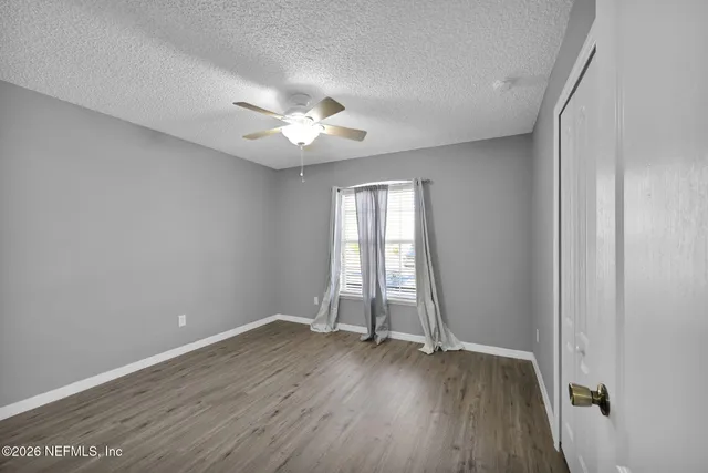 an empty room with wooden floor and window