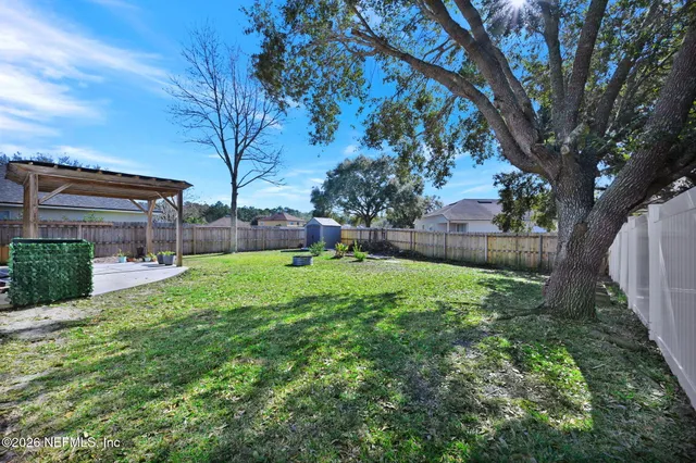 a sign that is sitting in front of a tree