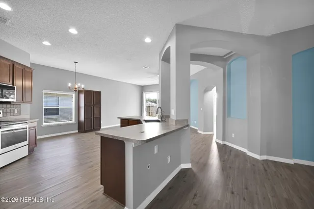 a kitchen with stainless steel appliances granite countertop cabinets wooden floor and a sink