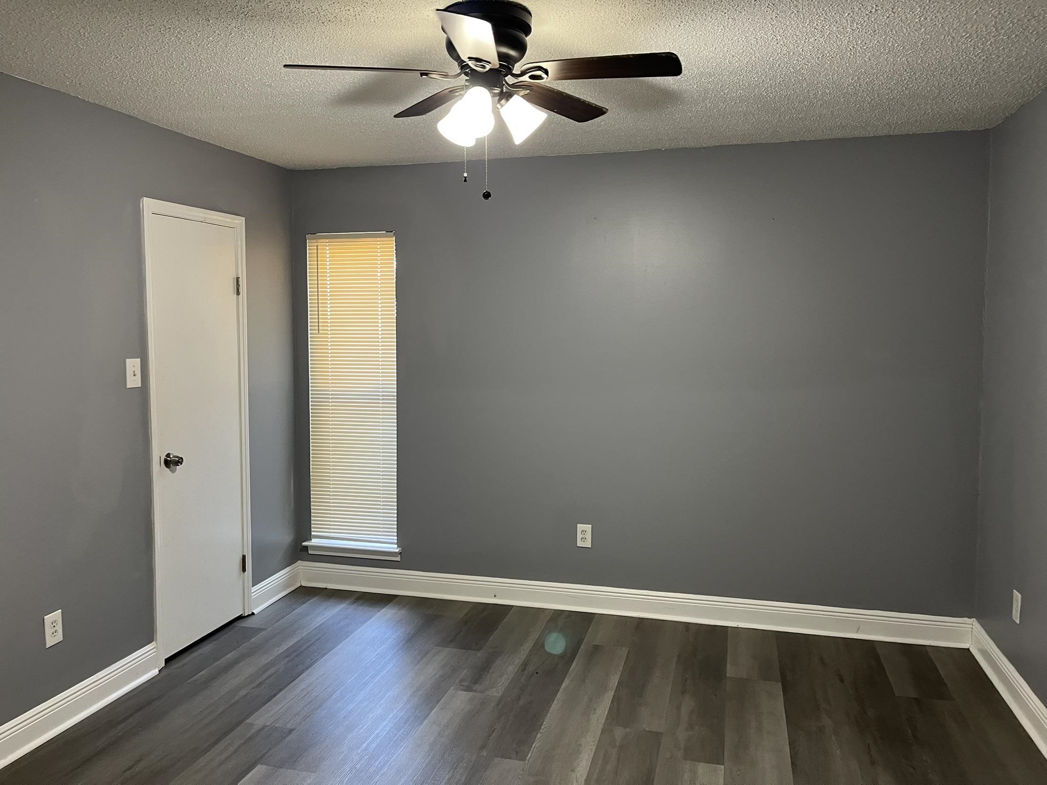 3273 Ridgemont Avenue Memphis, TN 38128 - Photo 14 of 16 an empty room with wooden floor fan and windows