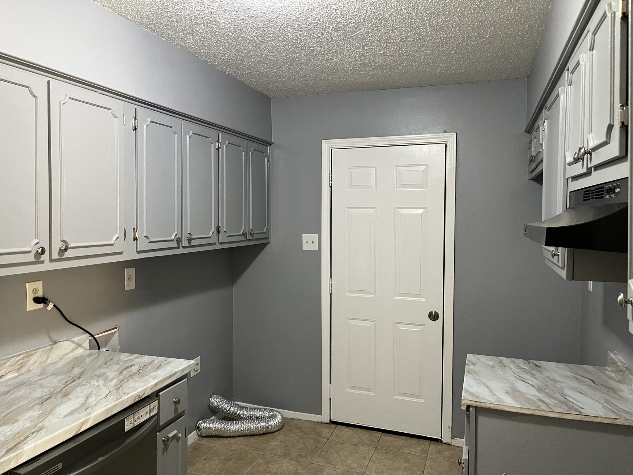 3273 Ridgemont Avenue Memphis, TN 38128 - Photo 7 of 16 a room with a granite countertop white cabinets and a wooden floor