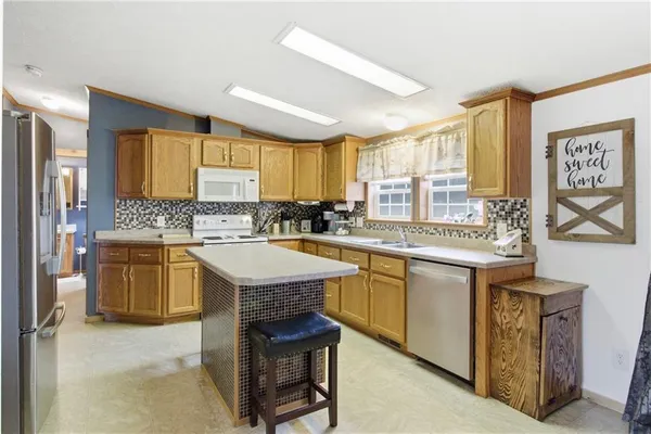 a kitchen with granite countertop a sink stove and cabinets