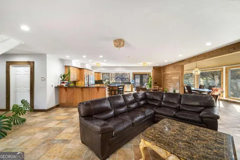 a view of a hallway with wooden floor and a living room