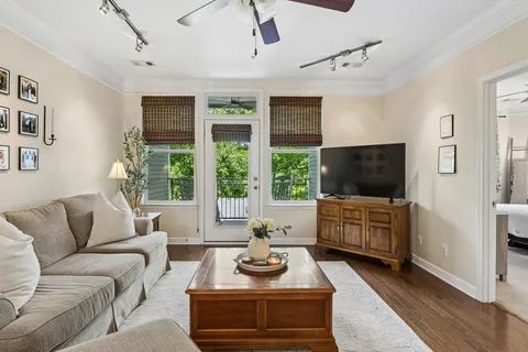 a living room with furniture a flat screen tv and a large window