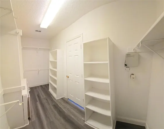 a view of walk in closet with empty racks