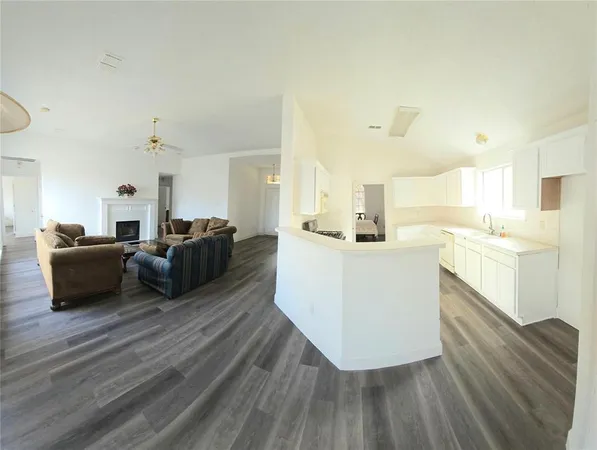 a large room with a lot of counter space and a wooden floor
