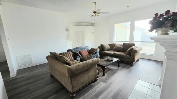 a living room with furniture and a wooden floor