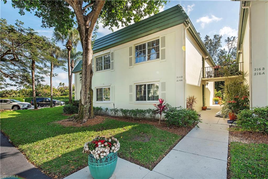 214 Bobolink Way, Unit 214B Naples, FL 34105 - Photo 1 of 12 a front view of a house with a garden