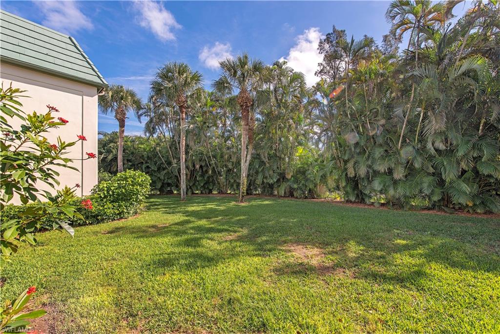 214 Bobolink Way, Unit 214B Naples, FL 34105 - Photo 12 of 12 a view of a big yard with plants and large trees