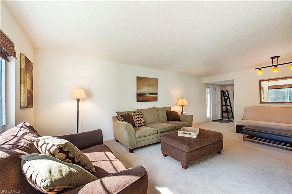 214 Bobolink Way, Unit 214B Naples, FL 34105 - Photo 3 of 12 a living room with furniture and a lamp
